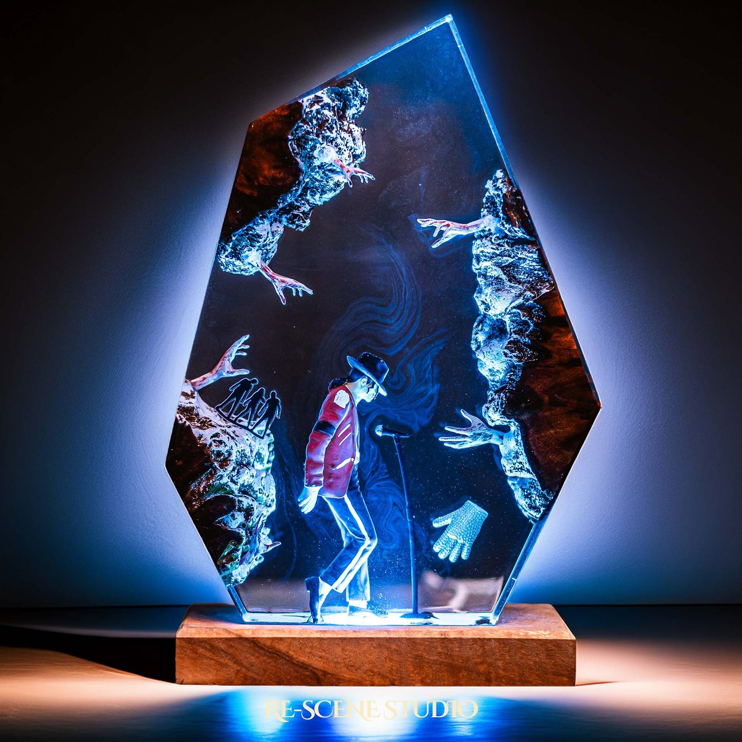 Handmade epoxy resin table lamp showing a dancer in a fedora and red jacket in a dramatic forward anti-gravity lean with reaching shadow hands, on a wood LED base (view 7)
