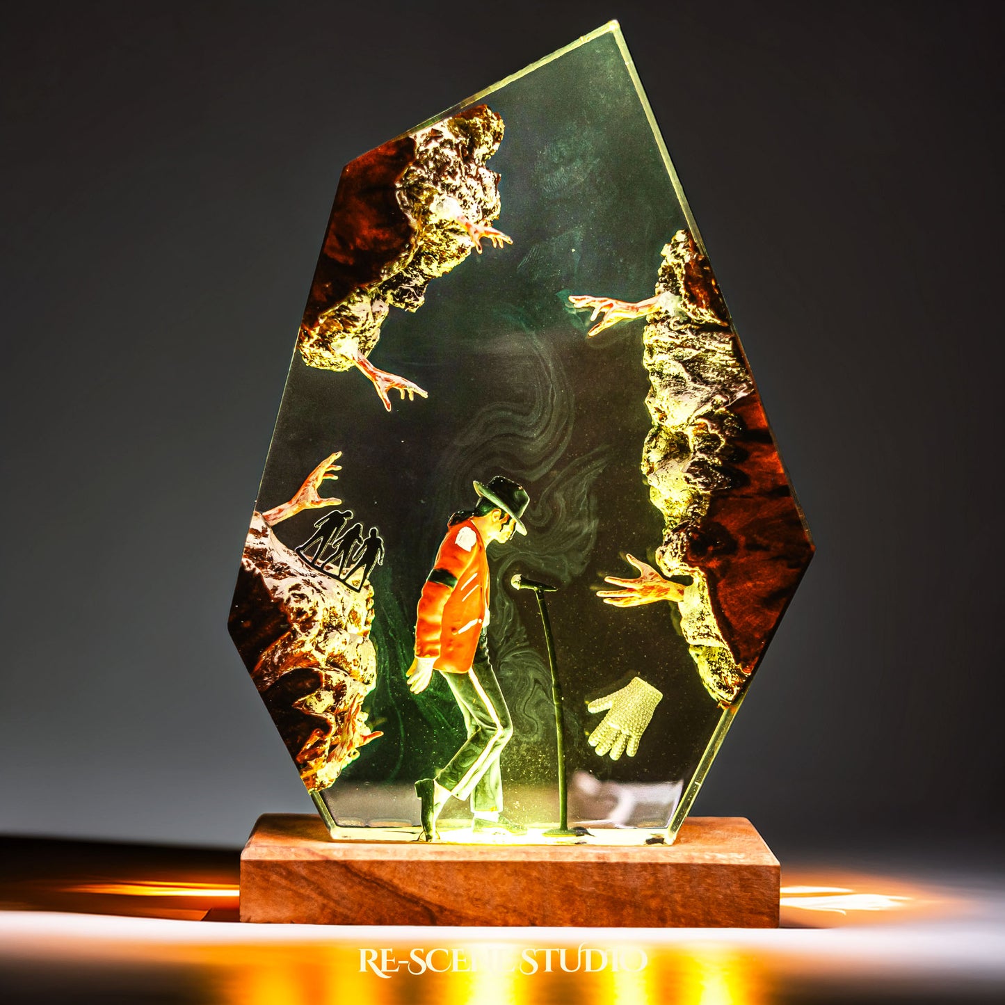 Handmade epoxy resin table lamp showing a dancer in a fedora and red jacket in a dramatic forward anti-gravity lean with reaching shadow hands, on a wood LED base (view 6)