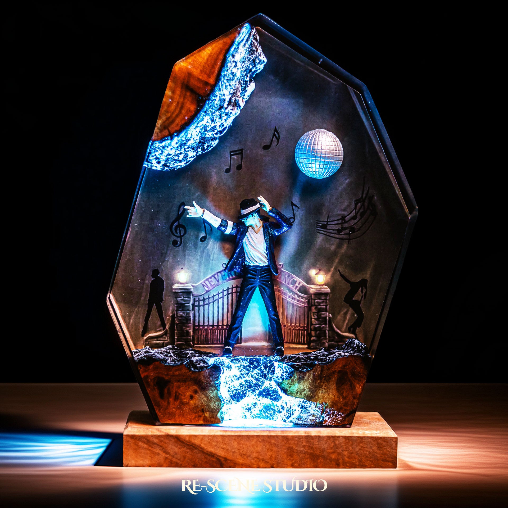 Handmade epoxy resin table lamp showing a dancer on a stage with a mirror ball and floating music notes, one arm raised, glowing from within on a natural wood LED base (view 3)