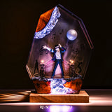 Handmade epoxy resin table lamp showing a dancer on a stage with a mirror ball and floating music notes, one arm raised, glowing from within on a natural wood LED base (view 1)