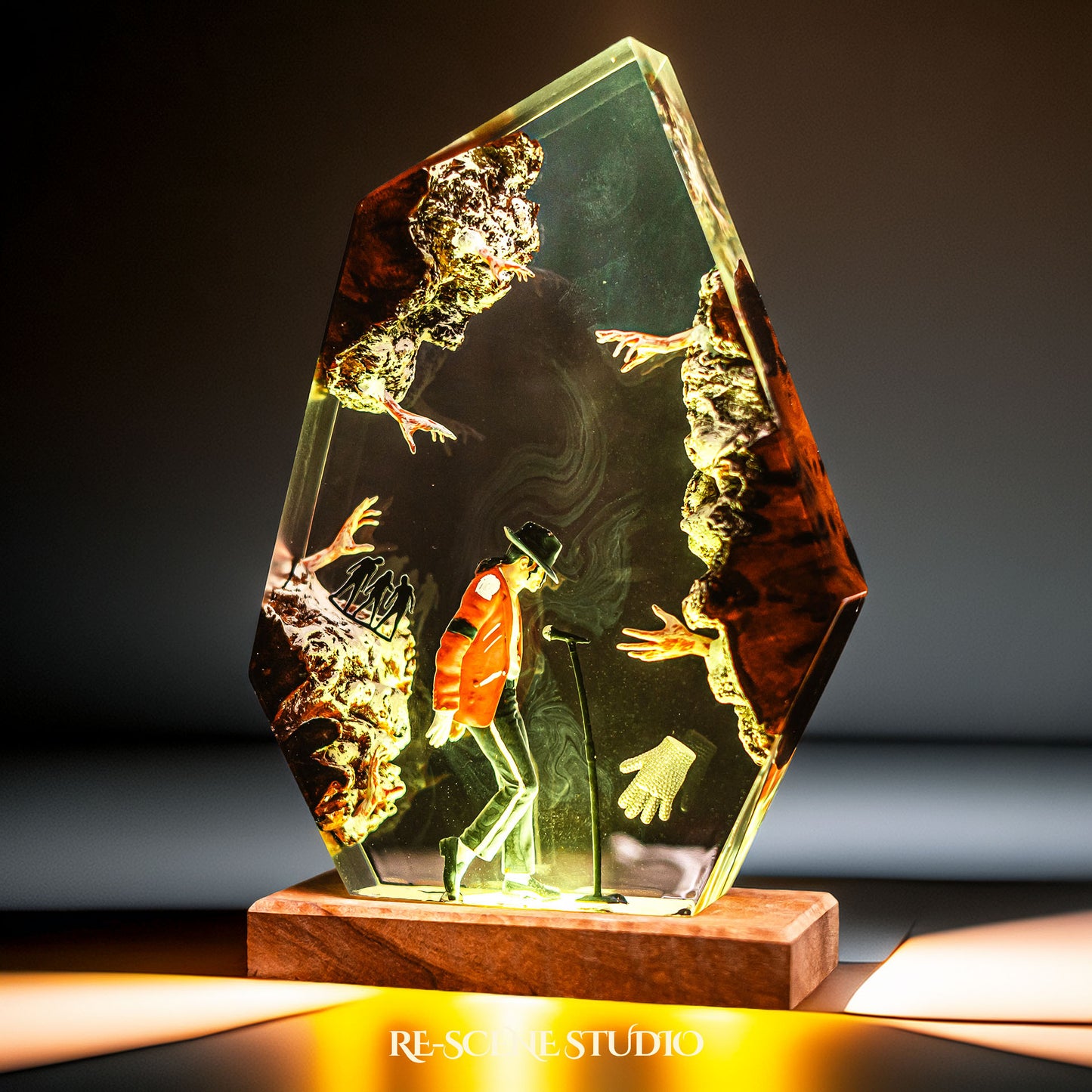 Handmade epoxy resin table lamp showing a dancer in a fedora and red jacket in a dramatic forward anti-gravity lean with reaching shadow hands, on a wood LED base (view 5)