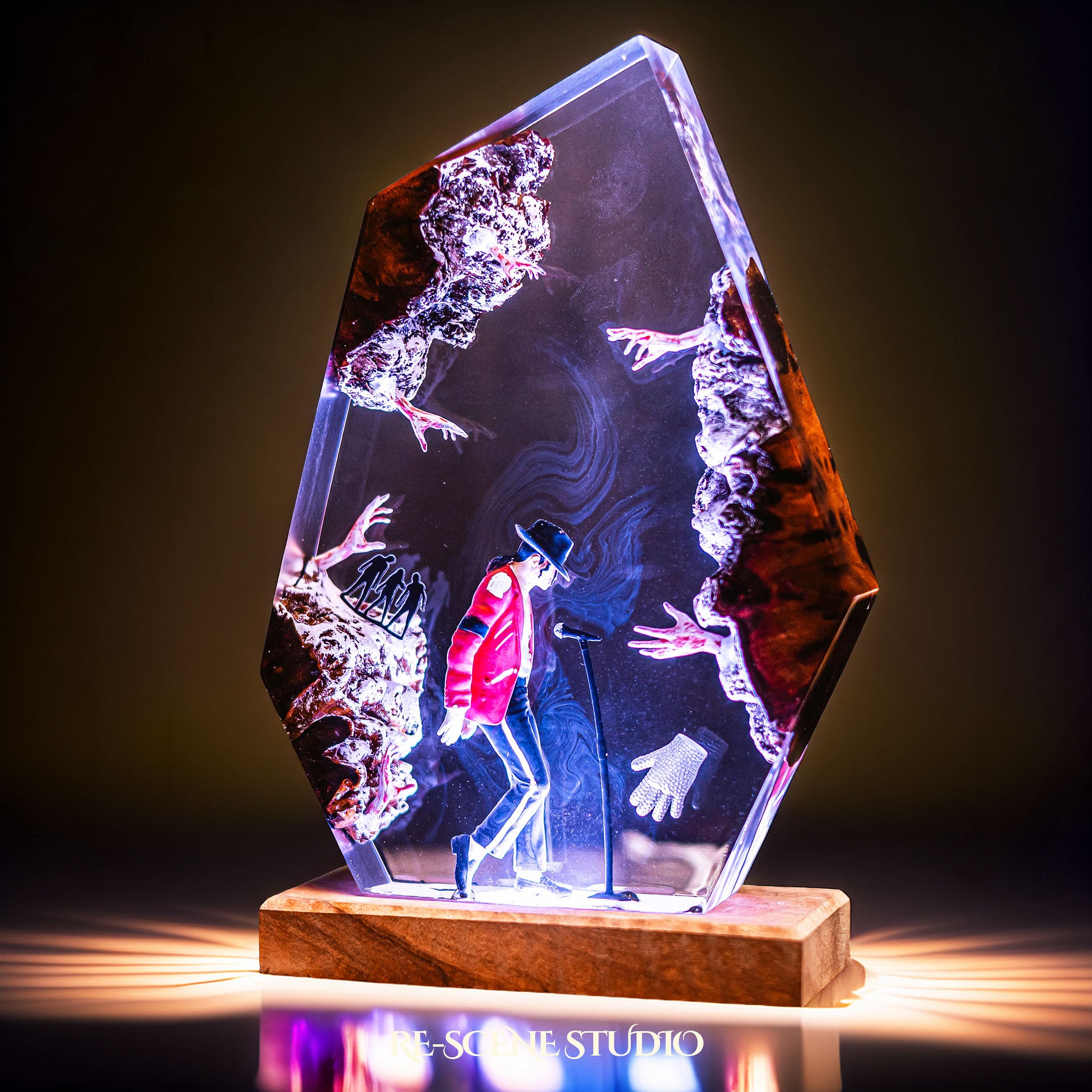 Handmade epoxy resin table lamp showing a dancer in a fedora and red jacket in a dramatic forward anti-gravity lean with reaching shadow hands, on a wood LED base (view 2)