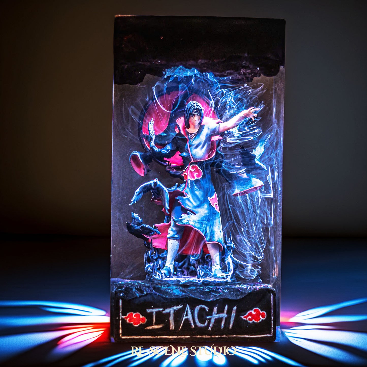 Black-cloaked crow ninja before a crimson moon handmade epoxy resin LED lamp on a wooden base – front view, lit