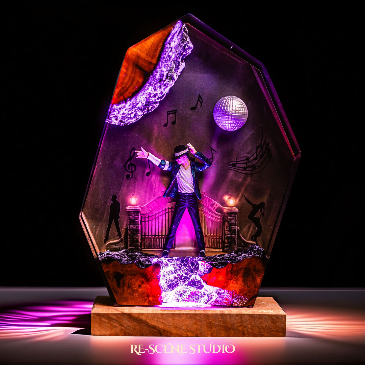 Handmade epoxy resin table lamp showing a dancer on a stage with a mirror ball and floating music notes, one arm raised, glowing from within on a natural wood LED base (view 2)