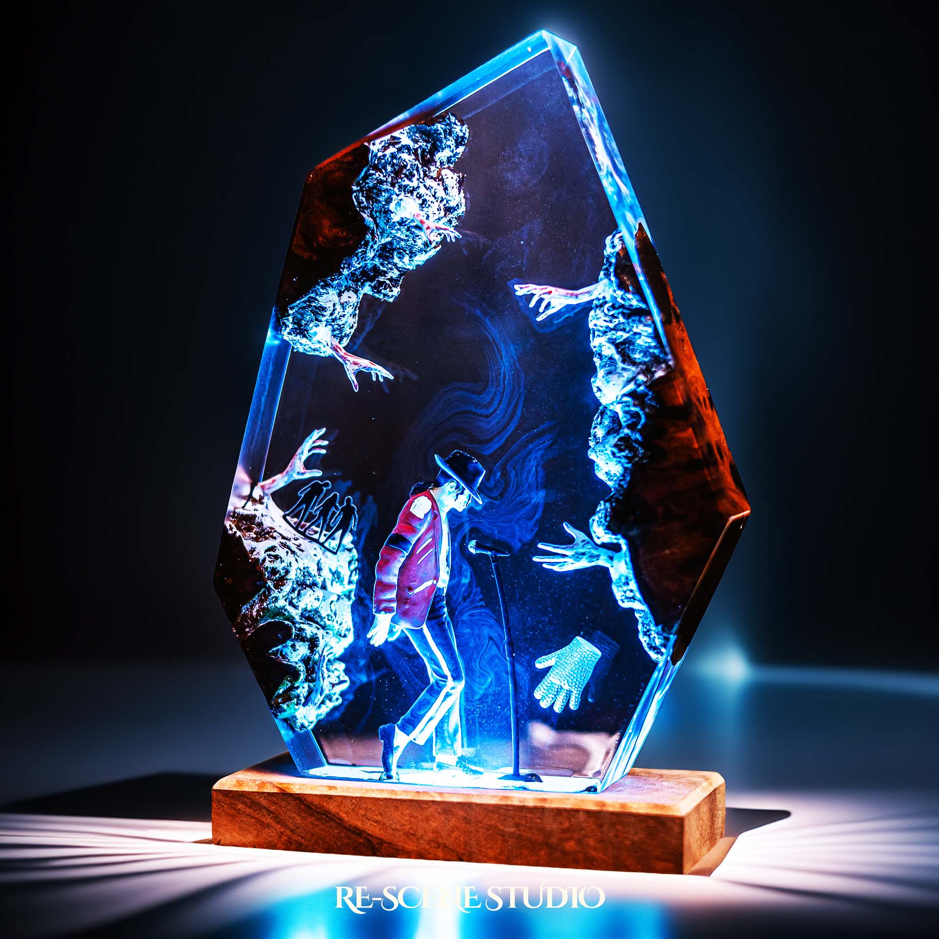 Handmade epoxy resin table lamp showing a dancer in a fedora and red jacket in a dramatic forward anti-gravity lean with reaching shadow hands, on a wood LED base (view 4)