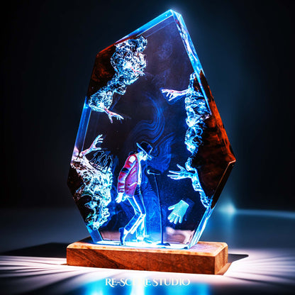 Handmade epoxy resin table lamp showing a dancer in a fedora and red jacket in a dramatic forward anti-gravity lean with reaching shadow hands, on a wood LED base (view 4)