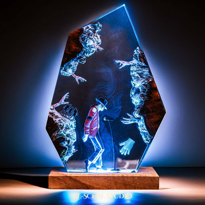 Handmade epoxy resin table lamp showing a dancer in a fedora and red jacket in a dramatic forward anti-gravity lean with reaching shadow hands, on a wood LED base (view 7)