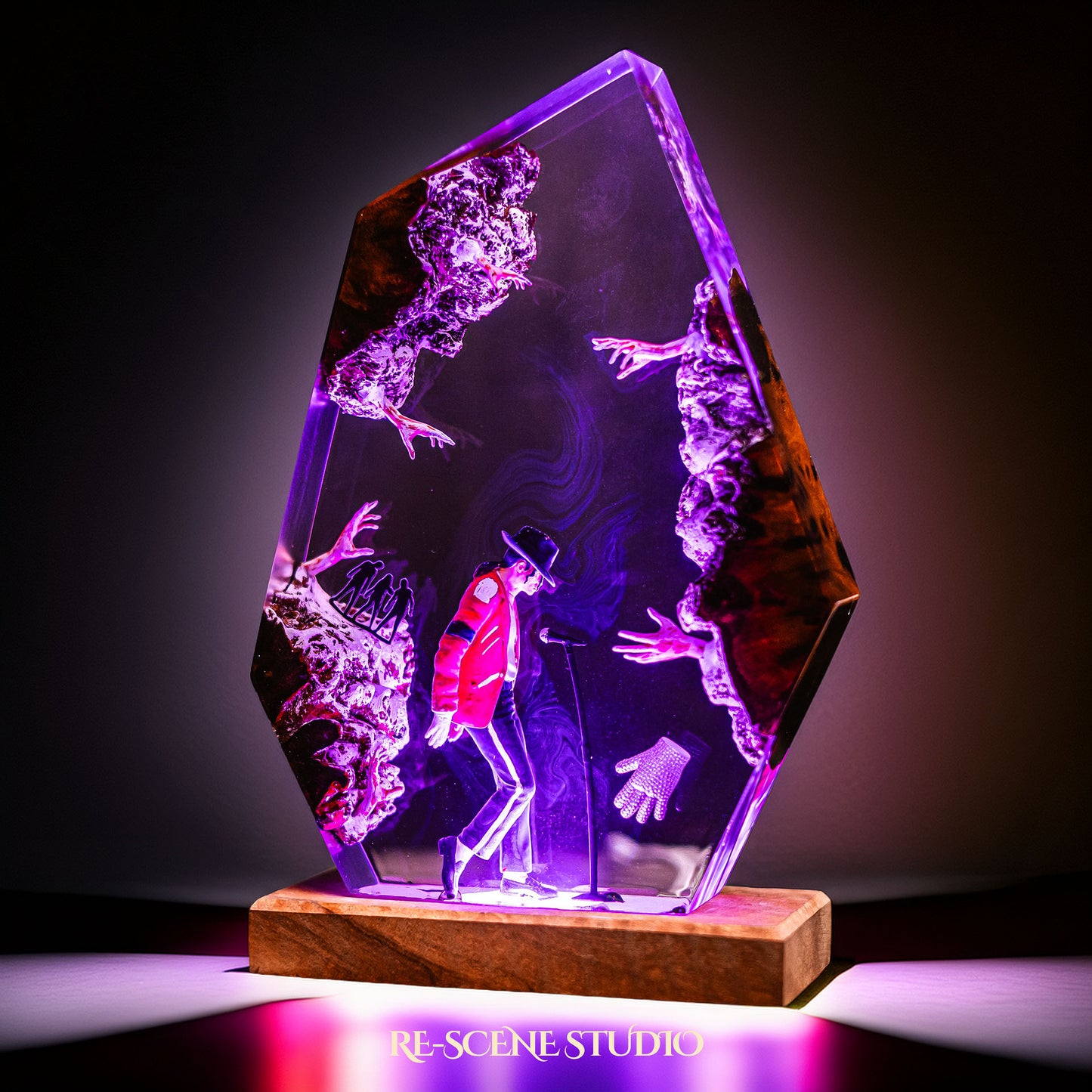 Handmade epoxy resin table lamp showing a dancer in a fedora and red jacket in a dramatic forward anti-gravity lean with reaching shadow hands, on a wood LED base (view 3)