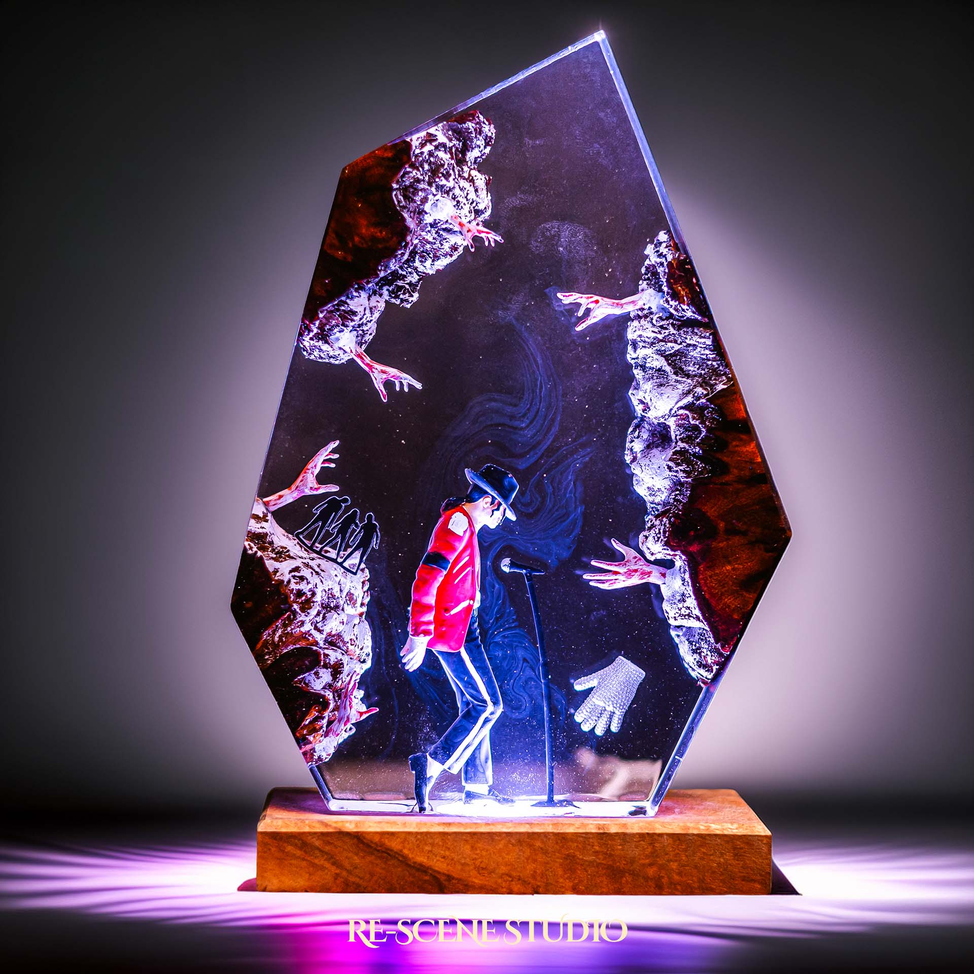 Handmade epoxy resin table lamp showing a dancer in a fedora and red jacket in a dramatic forward anti-gravity lean with reaching shadow hands, on a wood LED base (view 1)